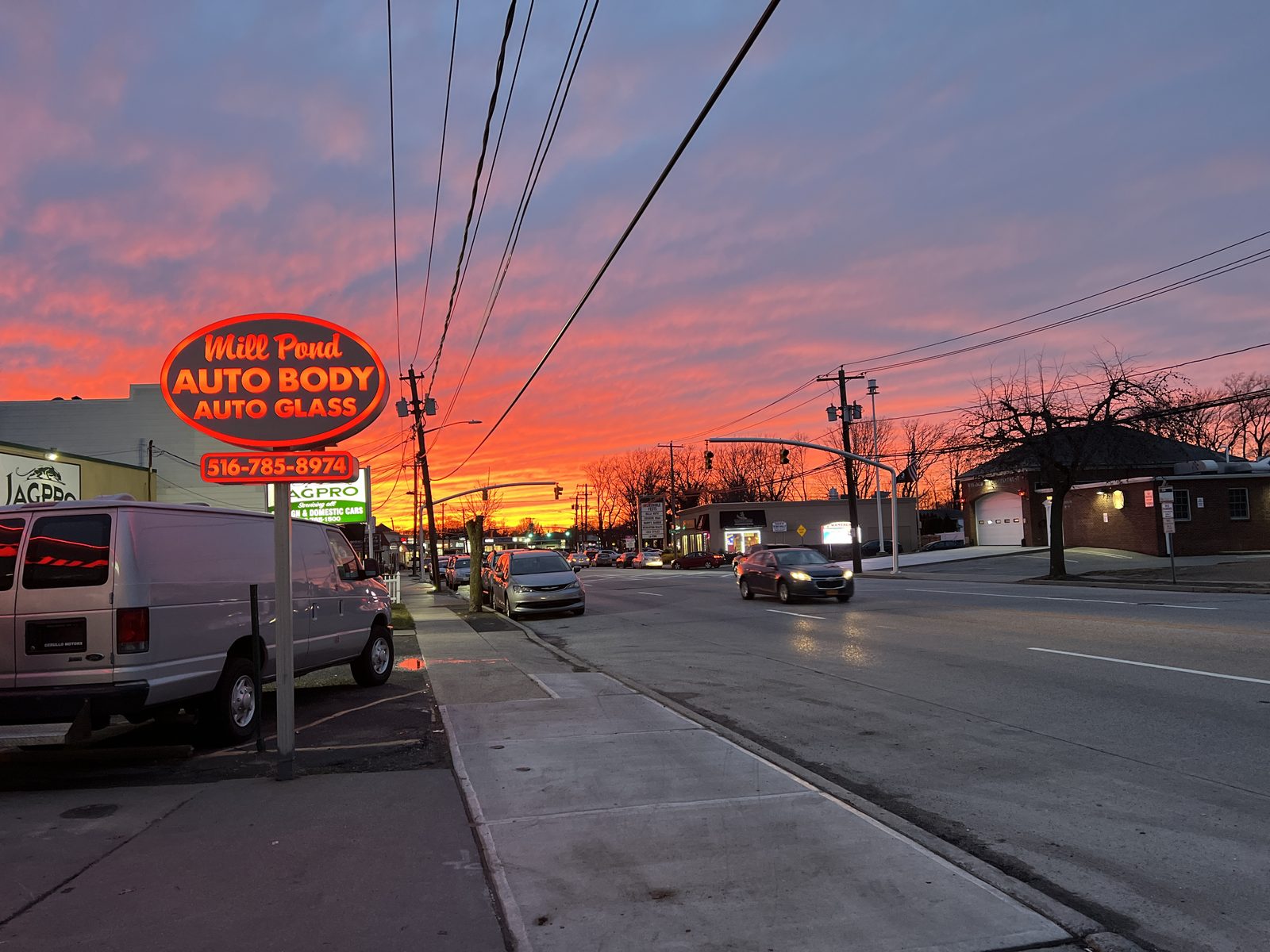 Mill Pond Auto Body & Glass storefront on Merrick Road at sunset